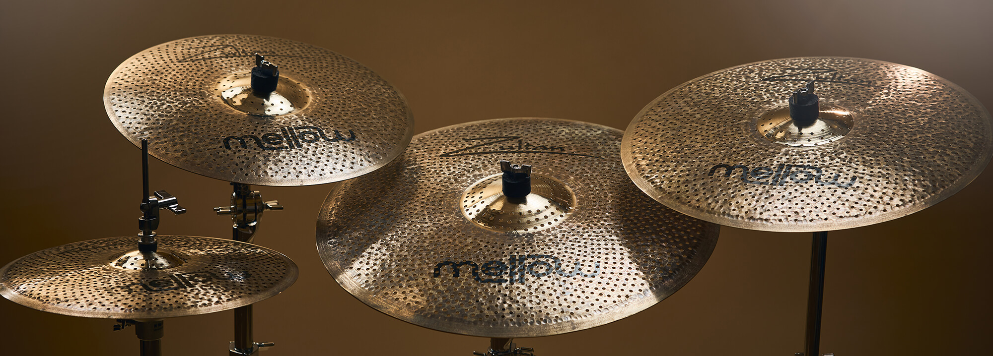 Four Zultan Mellow series cymbals of varying sizes, mounted on stands against a warm background.
